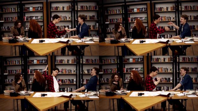 慢镜头:学生们在大学图书馆学习了几个小时后，一起玩乐。快乐和自由的学生——两个男人互相问候，打手势。