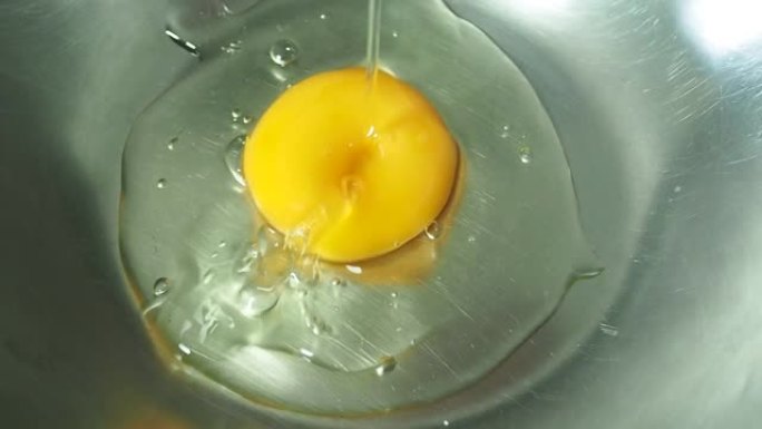 在碗里打碎鸡蛋。慢动作。