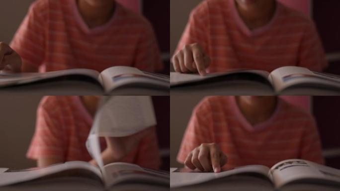 小女孩看书和翻页。女学生在阅读时沿着页面移动手指。
