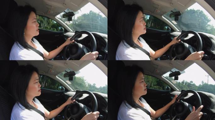 亚洲妇女驾驶汽车在道路上打开窗户侧视