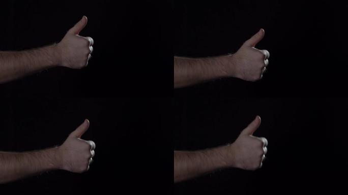 男人的手在黑色背景上显示拇指向上的手势。停电，4K