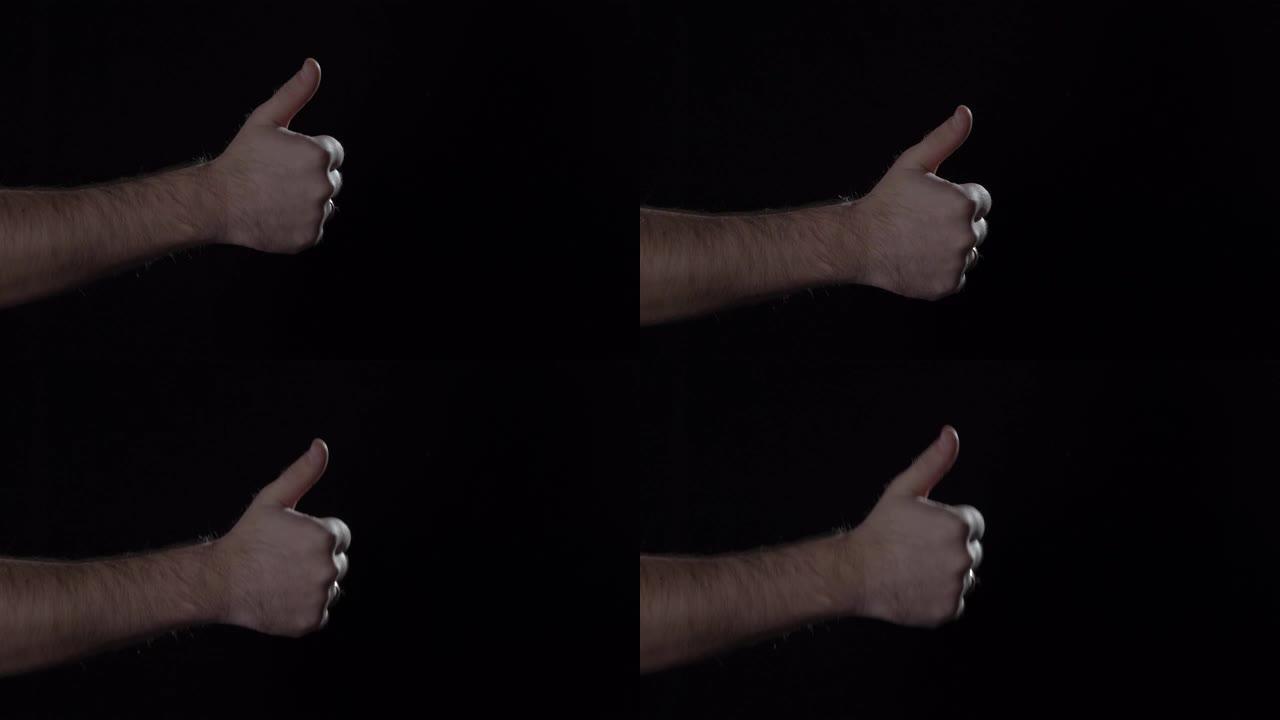 男人的手在黑色背景上显示拇指向上的手势。停电，4K