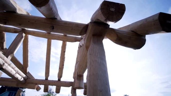 木制乡间别墅的框架正在用原木建造中。夹。蓝天背景下的木屋建设