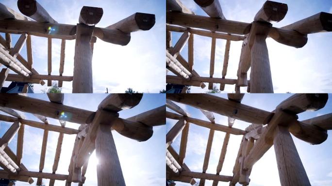 木制乡间别墅的框架正在用原木建造中。夹。蓝天背景下的木屋建设