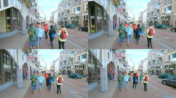 一群游客在阿姆斯特丹的街道上漫步。