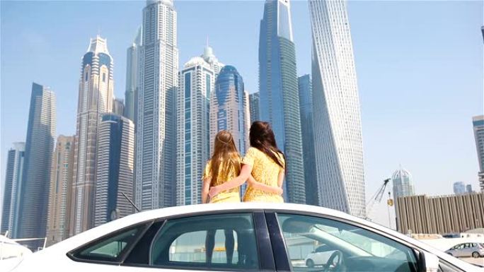 家庭暑假。妈妈和孩子在迪拜摩天大楼的背景下度假