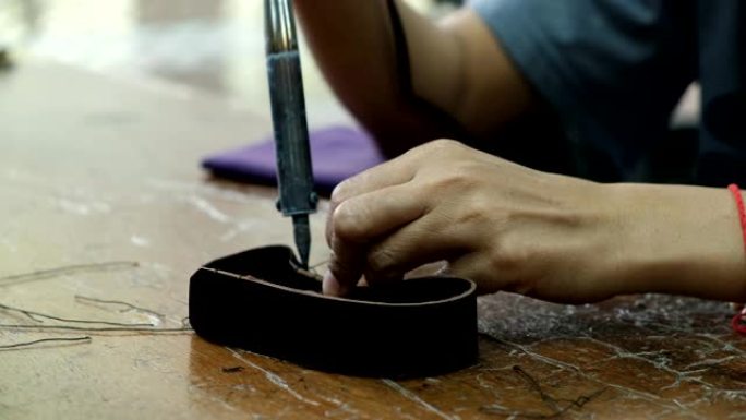 皮革工厂背景中涂胶和修剪裁缝的特写