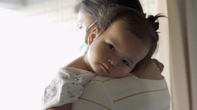 生病的女婴睡在母亲的肩膀上