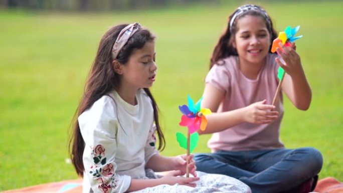 两个漂亮的年轻女孩和朋友在公园玩涡轮机阳光明媚的秋天在公园里，在公园里说笑