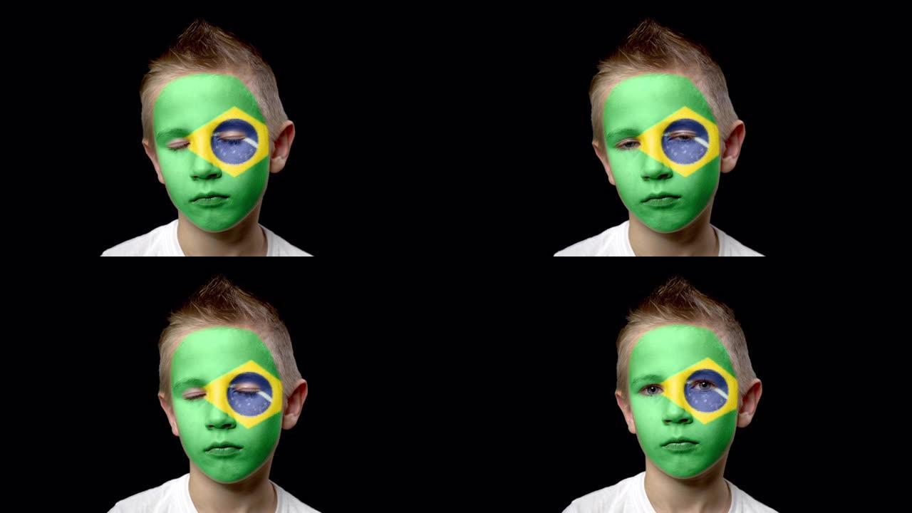 巴西足球队的悲伤球迷。一个脸上涂着民族色彩的孩子。