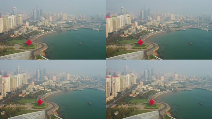 阳光明媚的日落青岛市著名的市中心海湾广场空中全景4k中国