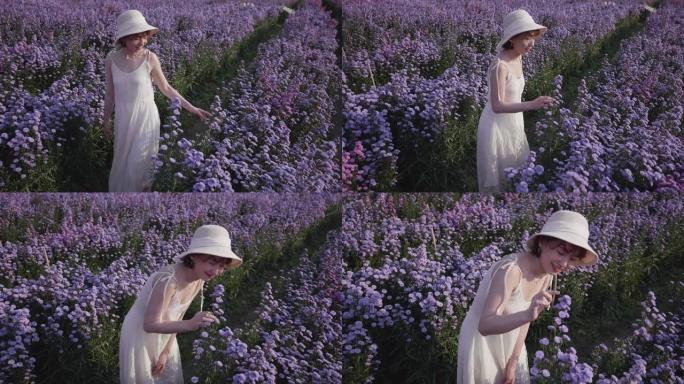 一个年轻的女人在阳光明媚的日子里轻轻地手里拿着鲜花，闻到紫色的花朵。慢动作