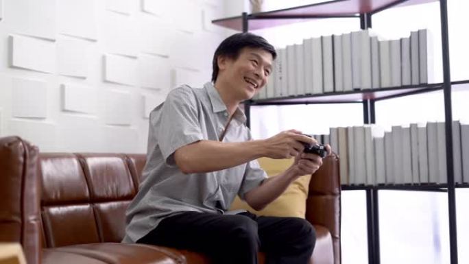 亚洲成熟的老年人在家里的客厅玩电子游戏快乐刺激的情感