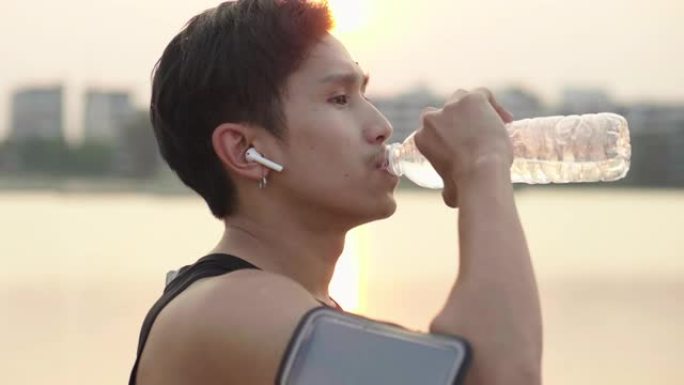 亚洲男子运动员在城市跑步后饮水