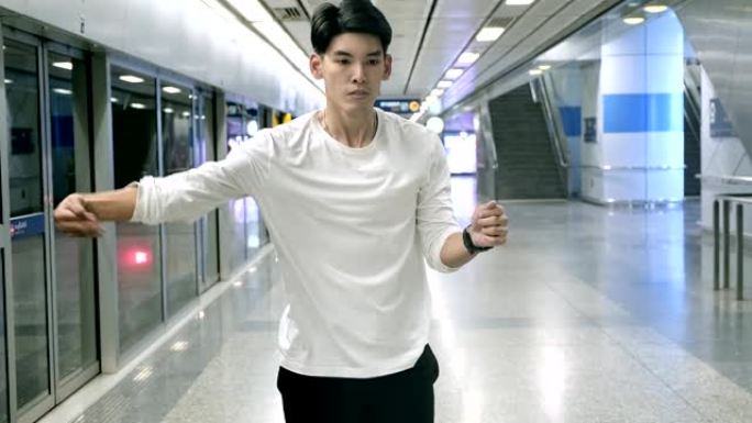 年轻人在地铁站做自由式街舞的中等镜头。亚洲男人。