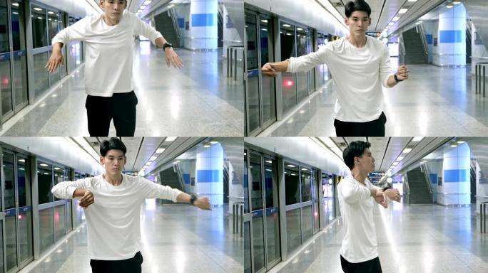 年轻人在地铁站做自由式街舞的中等镜头。亚洲男人。