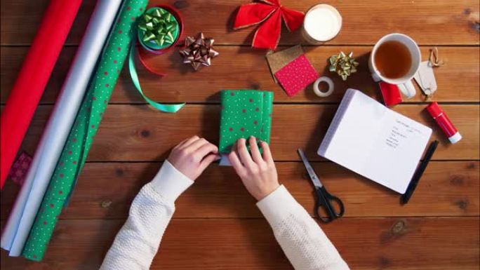 双手包装圣诞礼物和书写笔记