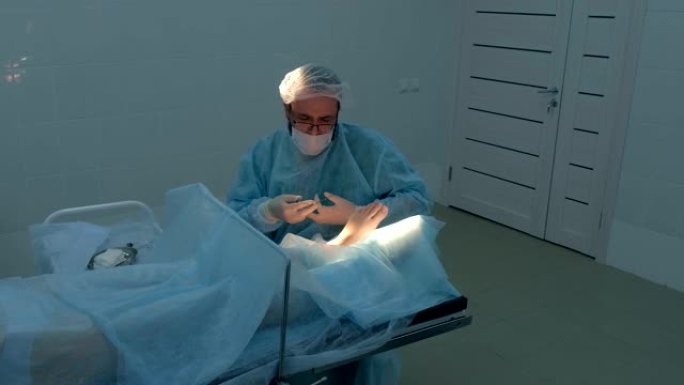 外科医生在医院做腿部踝部湿瘤切除手术。