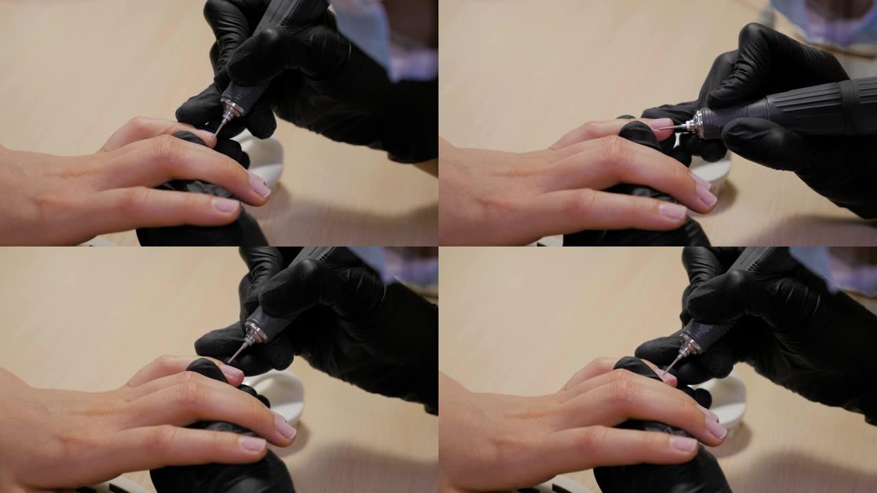 美甲师使用便携式笔形电动指甲钻。开始修指甲。在指甲油机器的帮助下修指甲。
