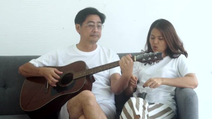 夫妻弹吉他，一起快乐地唱歌。