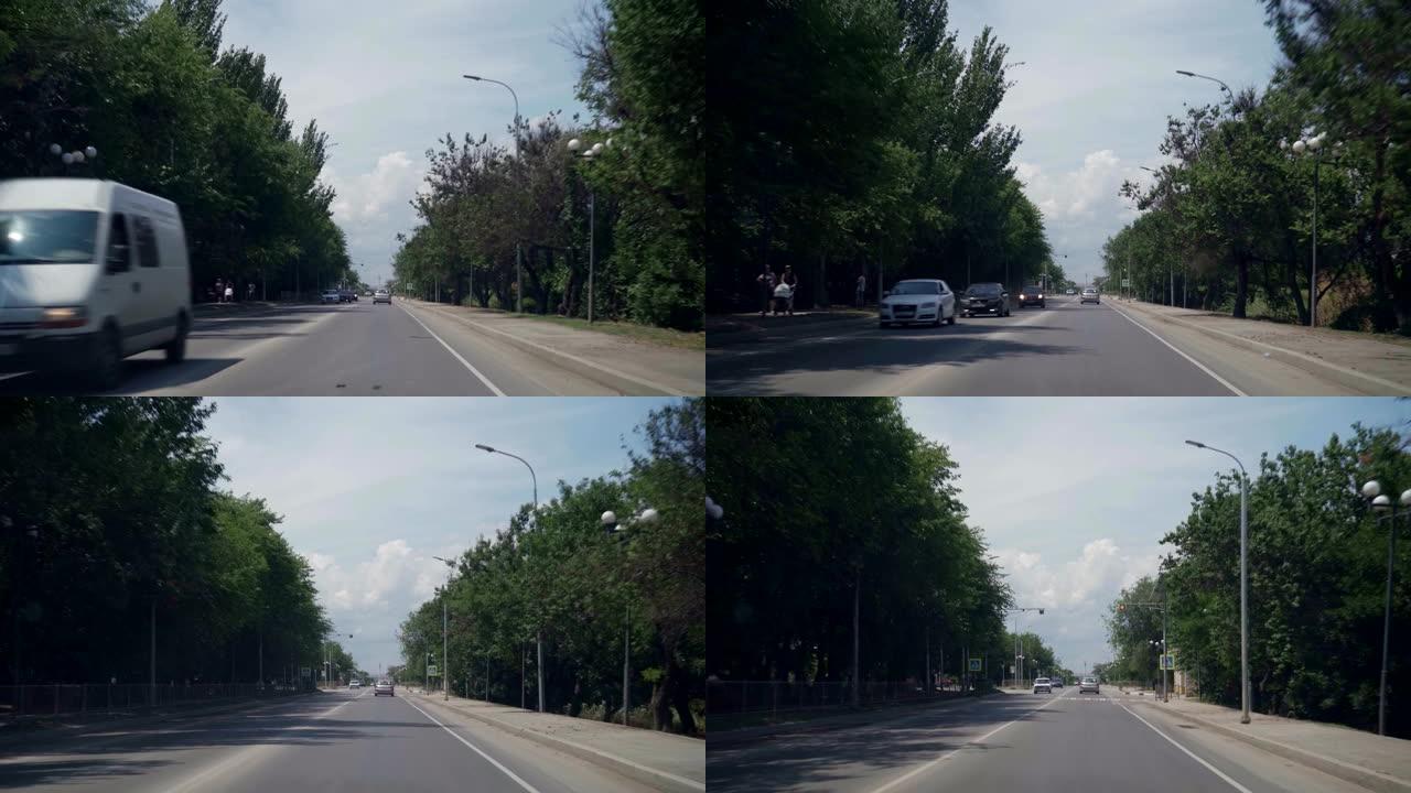 夏天的路，两边是绿树。从车里看。