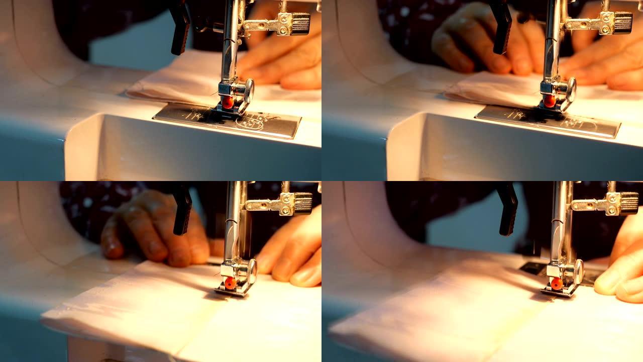 裁缝过程-妇女的手使用带有内置灯的缝纫机，可以制作纺织服装。