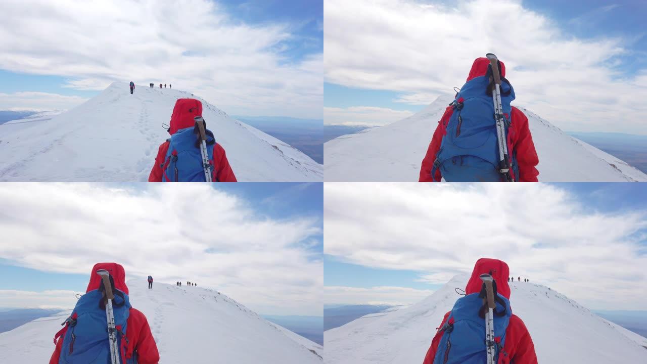 冬季，女性高山登山者与她的团队一起在高海拔的山峰上移动。