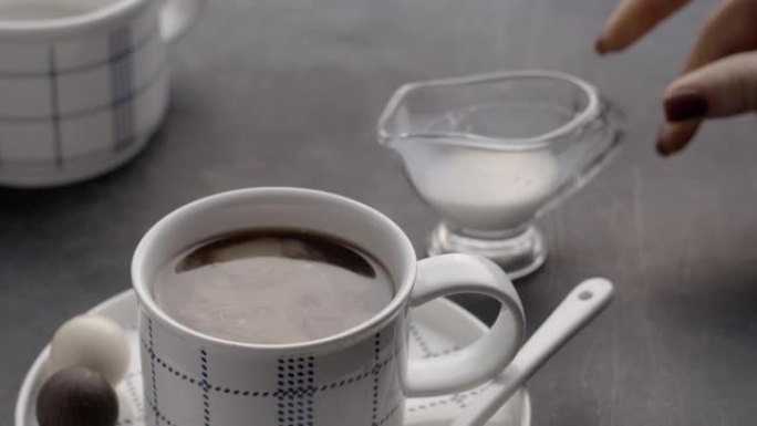 将奶油倒入黑咖啡中，然后用勺子混合。