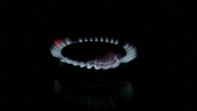 厨房燃烧器打开。炉顶燃烧器点燃成蓝色烹饪火焰。黑色背景。天然气发炎，特写。镜头1080p.视频。