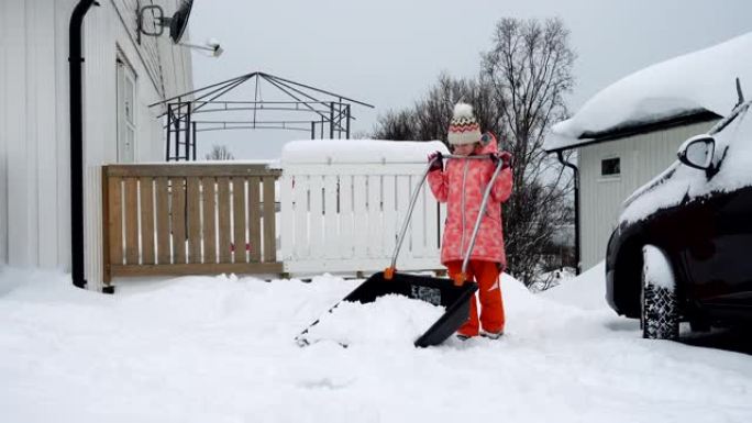 冬季暴风雪后，童女帮助用铁锹清理积雪。