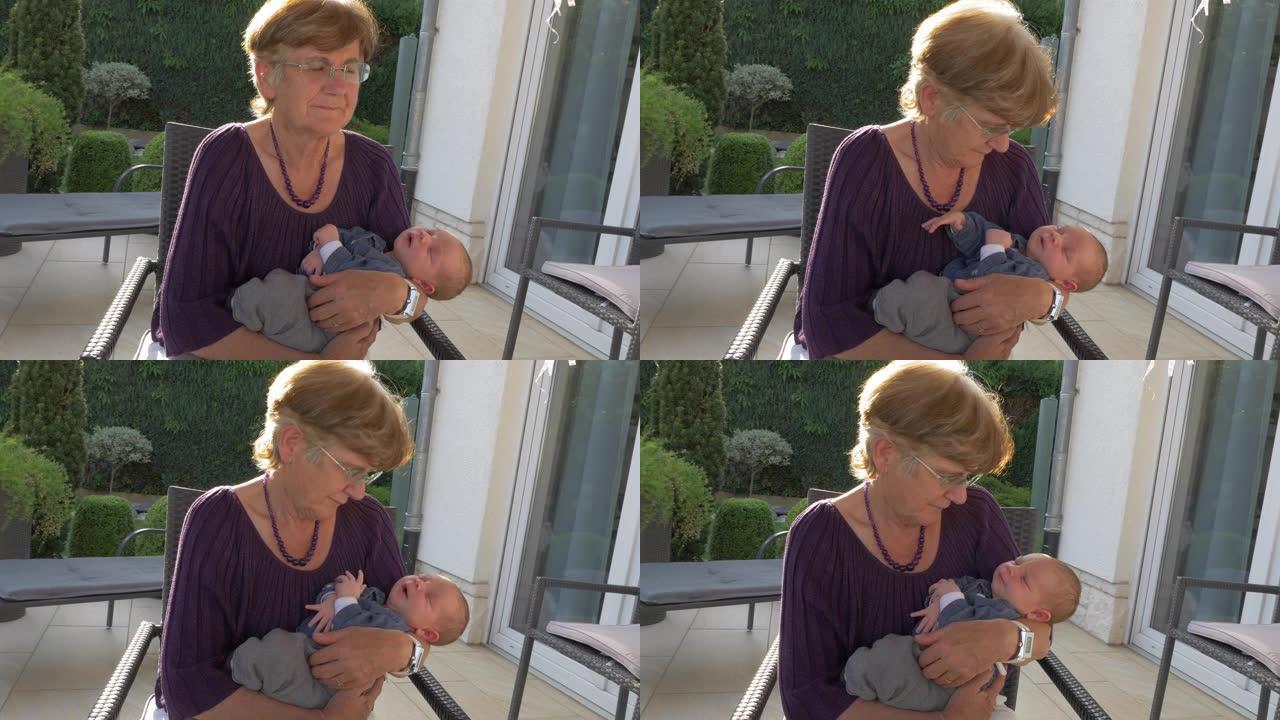 祖母在室外露台上抱着新生婴儿