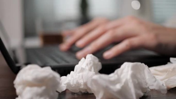 女性的手在脏纸手帕旁边的键盘上打字。感冒，流感，鼻塞，生病的人在工作或学校，没有休息日，低工资，没有