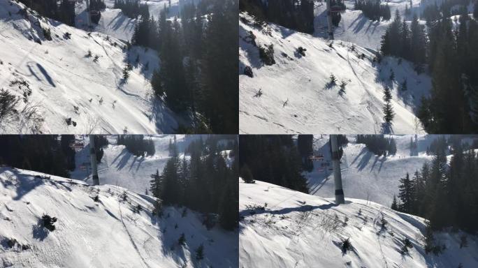 滑雪者在下面的滑雪椅上的鸟瞰图，山坡上风景秀丽的松树