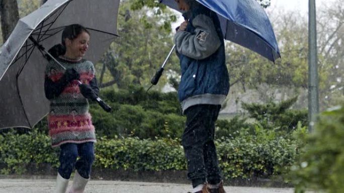 男孩和一个女孩在慢动作的倾盆大雨中跳伞