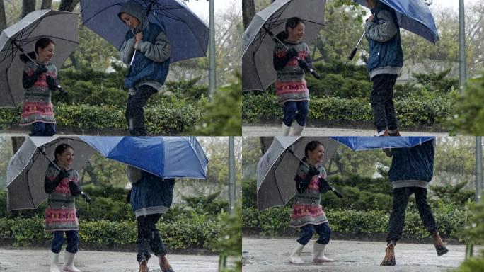 男孩和一个女孩在慢动作的倾盆大雨中跳伞