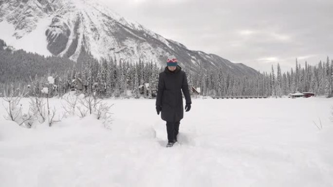 亚洲女子在翡翠湖雪林徒步旅行