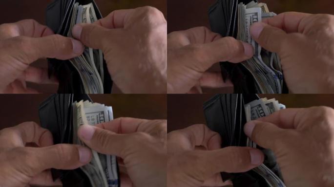 一位商人的特写镜头在钱包中数百美元的钞票
