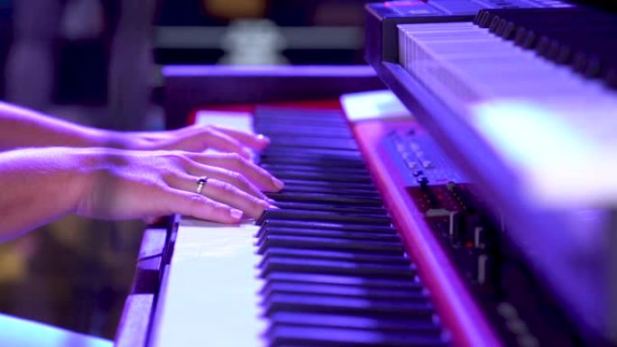双手放在键盘上慢动作弹奏钢琴。