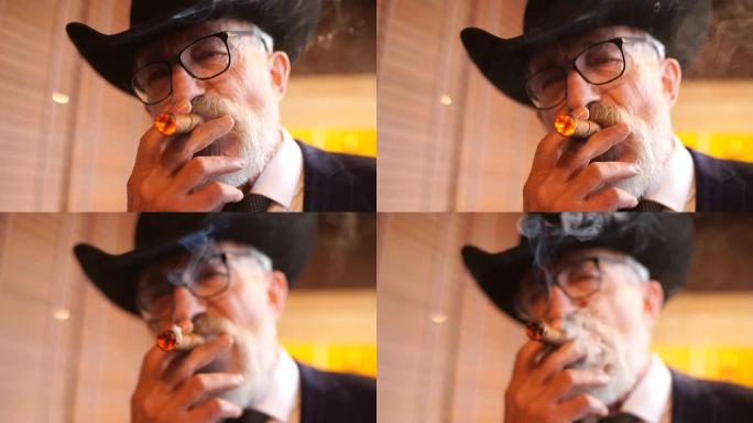 穿着宽边帽的时尚老人和丰富的蓝色男士套装室内吸烟雪茄