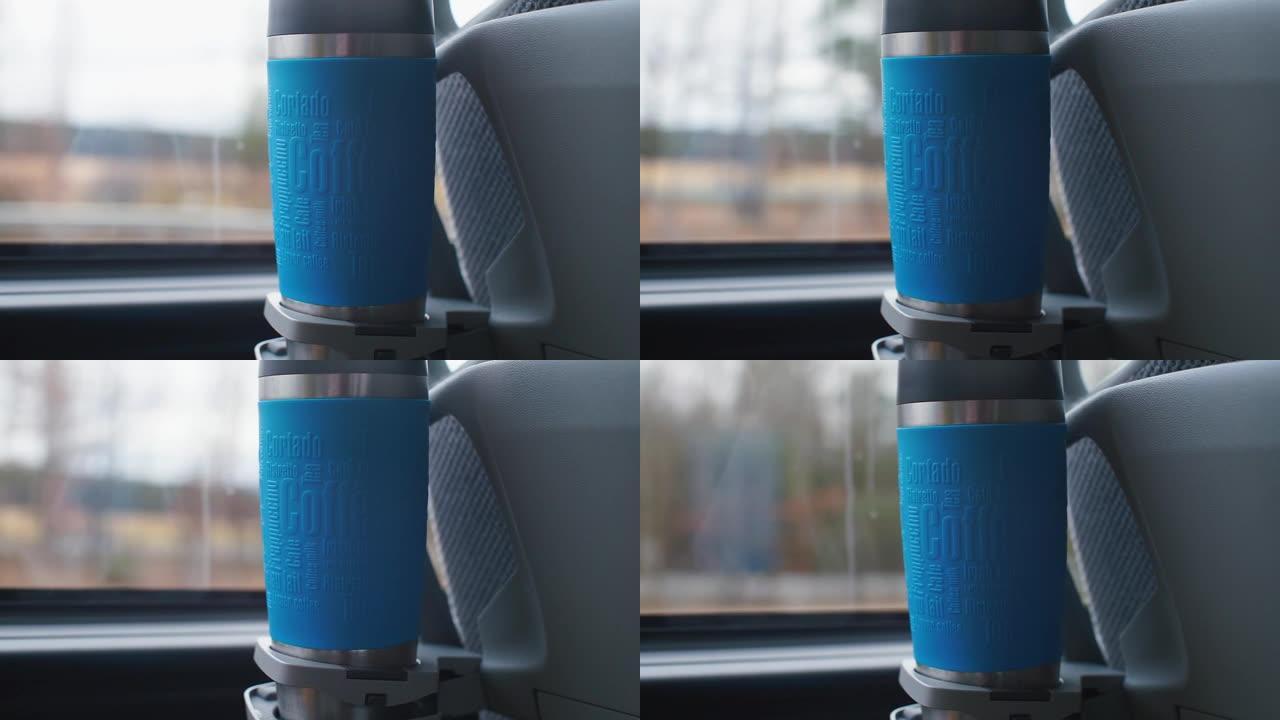 带热饮的热水瓶在旅游巴士的杯架中。