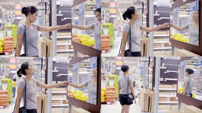亚洲女性顾客购物和选择餐桌和书籍货架木材作为家庭装饰。亚洲女性在购物商店购买五金和家具。