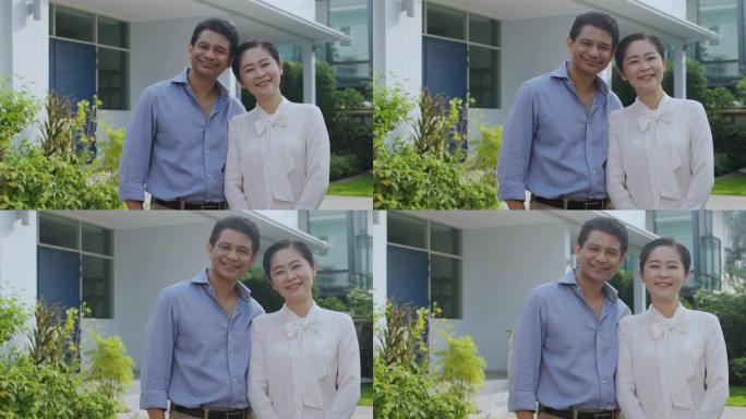 高级夫妇在他们家门口的肖像。快乐时刻。背面摄像头。慢动作。50多岁的亚洲男女。