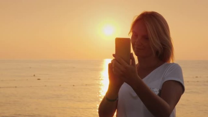 一个女人在太阳升起的背景下为自己拍照的剪影