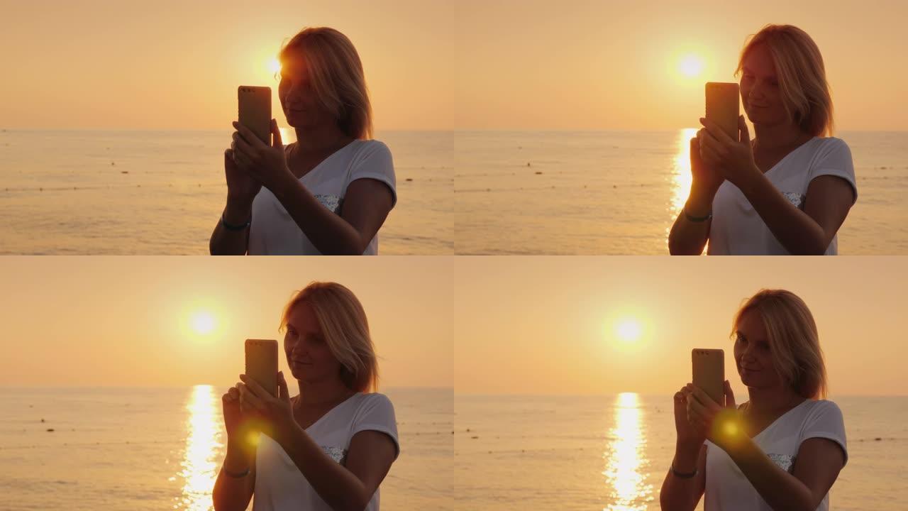 一个女人在太阳升起的背景下为自己拍照的剪影