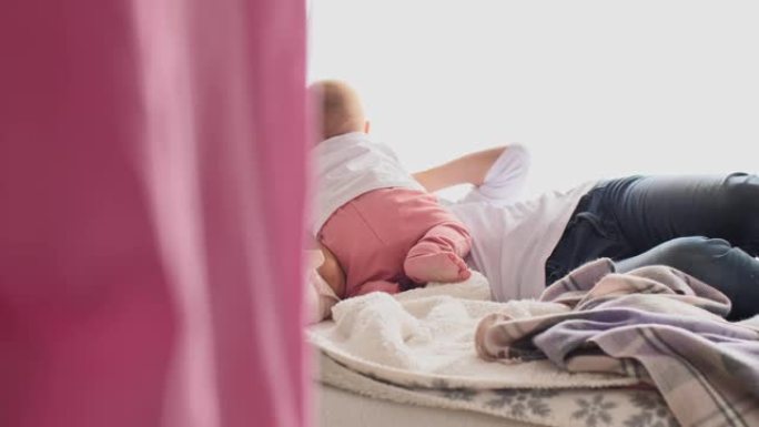 女婴在床上滚动并一起玩耍时与母亲建立联系