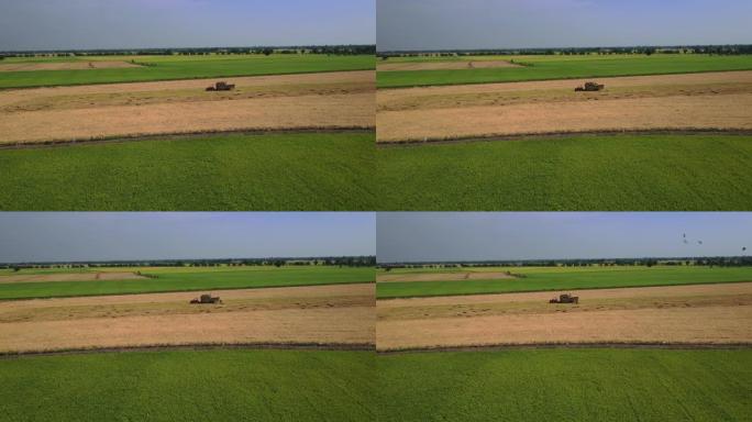 鸟瞰车拖拉机携带圆形圆柱形稻草堆，用于运输到现场
