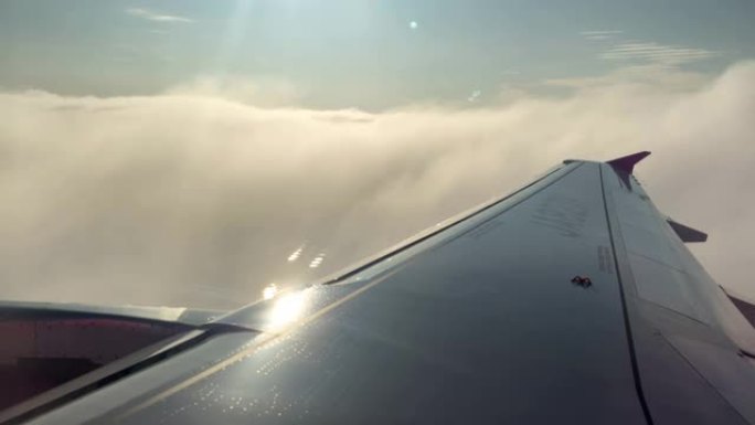 4K，飞机机翼在起飞时穿过白云。飞行旅行。