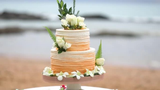 美丽的婚礼蛋糕装饰着鲜花和橙色。
