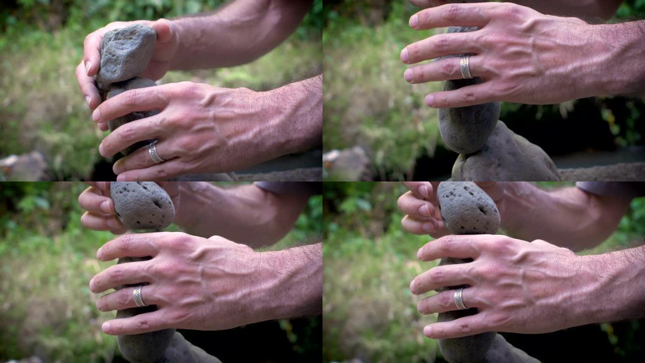 一个男人在大自然中平衡岩石的特写4k镜头