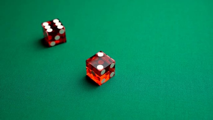 经销商掷骰子七个。慢动作两个红色骰子，掷骰子，扔在赌场的绿色tomentum背景上，自然或七个。成人